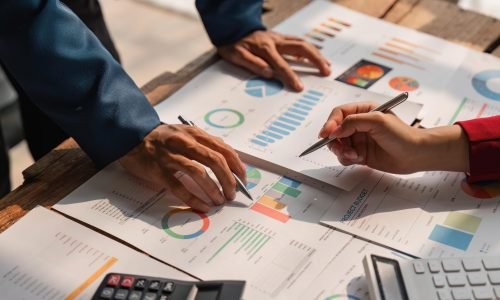 Business team analyzes financial business finance reports on laptop and graph documents during corporate meeting discussions showing successful teamwork, business meeting ideas.